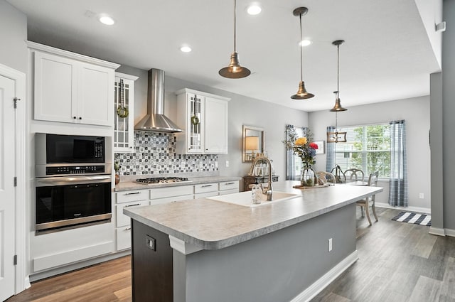 618 Ludham Trl, Pickerington, OH 43147 - kitchen featuring stainless steel appliances, wall chimney exhaust hood, light countertops, tasteful backsplash, and glass insert cabinets
