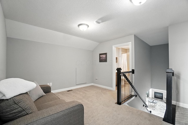 618 Ludham Trl, Pickerington, OH 43147 - sitting room featuring an upstairs landing, carpet floors, vaulted ceiling, and a textured ceiling