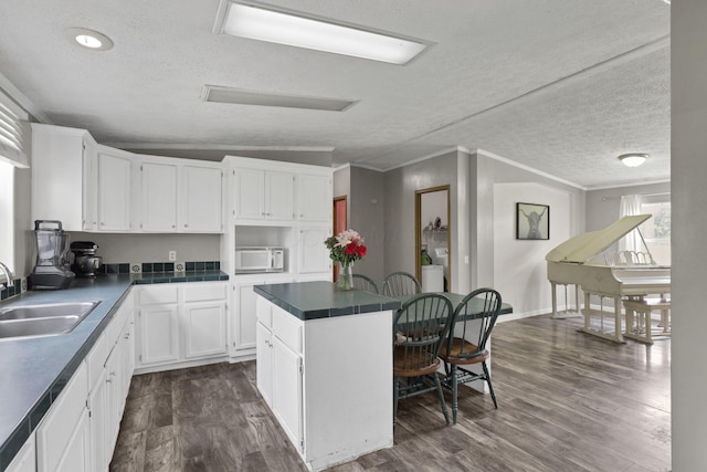 6471 Graham Rd, Mount Vernon, OH 43050 - kitchen with a center island, white microwave, a textured ceiling, white cabinets, and dark wood finished floors