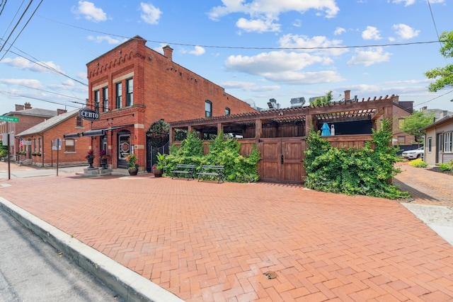 117 E Frankfort St, Columbus, OH 43206 - view of front of home with brick siding, a gate, and a pergola