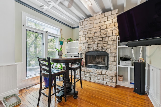 117 E Frankfort St, Columbus, OH 43206 - dining space featuring beam ceiling, a fireplace, wood-type flooring, and a wainscoted wall