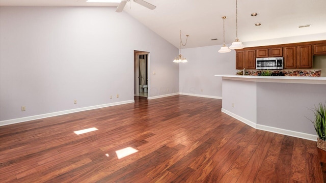 74 Stonington Cir, Newark, OH 43055 - kitchen with stainless steel microwave, ceiling fan, brown cabinets, light countertops, and high vaulted ceiling