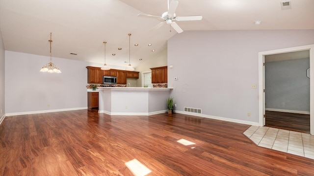 74 Stonington Cir, Newark, OH 43055 - unfurnished living room with ceiling fan, dark wood finished floors, a chandelier, and high vaulted ceiling