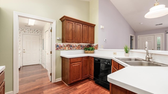74 Stonington Cir, Newark, OH 43055 - kitchen featuring dishwasher, vaulted ceiling, wood finished floors, light countertops, and brown cabinets