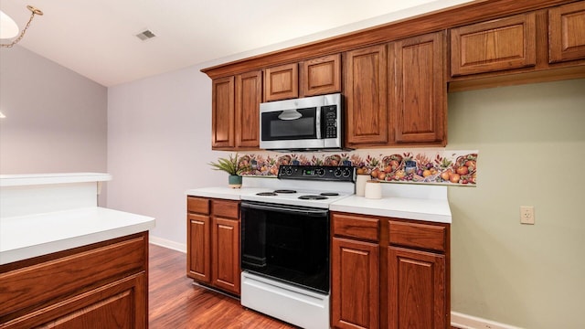 74 Stonington Cir, Newark, OH 43055 - kitchen featuring white electric range, stainless steel microwave, brown cabinetry, dark wood-style floors, and light countertops