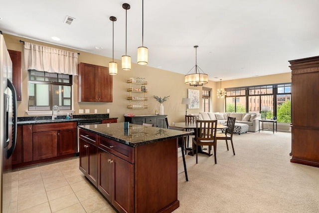 250 Daniel Burnham Sq Unit 402, Columbus, OH 43215 - kitchen with a center island, pendant lighting, dark stone counters, a breakfast bar area, and a chandelier