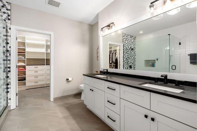 250 Daniel Burnham Sq Unit 402, Columbus, OH 43215 - bathroom featuring a walk in closet, double vanity, and a stall shower