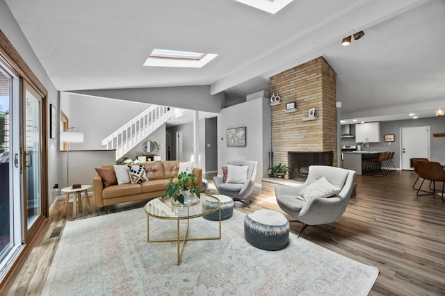 298 Flint Ridge Dr, Columbus, OH 43230 - living area with vaulted ceiling, a skylight, wood finished floors, stairs, and a large fireplace