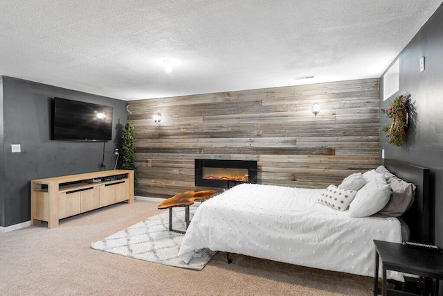 486 Ruffin Dr, Galloway, OH 43119 - bedroom featuring wooden walls, light colored carpet, an accent wall, a glass covered fireplace, and a textured ceiling