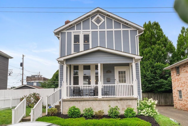 497 E Kossuth St, Columbus, OH 43206 - tudor home with covered porch, a chimney, and board and batten siding