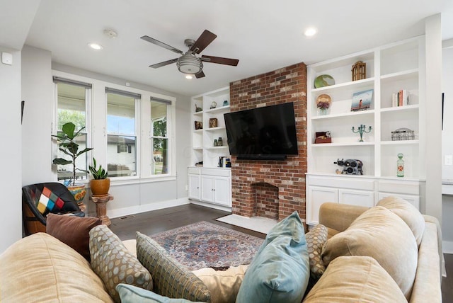 497 E Kossuth St, Columbus, OH 43206 - living room with dark wood finished floors, ceiling fan, recessed lighting, built in shelves, and a brick fireplace