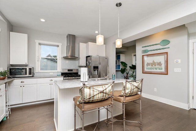 497 E Kossuth St, Columbus, OH 43206 - kitchen featuring appliances with stainless steel finishes, wall chimney range hood, dark wood-type flooring, decorative backsplash, and recessed lighting