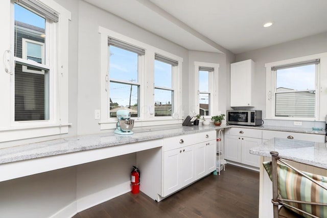 497 E Kossuth St, Columbus, OH 43206 - kitchen with stainless steel microwave, white cabinets, recessed lighting, dark wood-style flooring, and light stone countertops