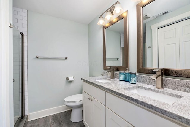 497 E Kossuth St, Columbus, OH 43206 - bathroom featuring double vanity, a shower, and wood finished floors