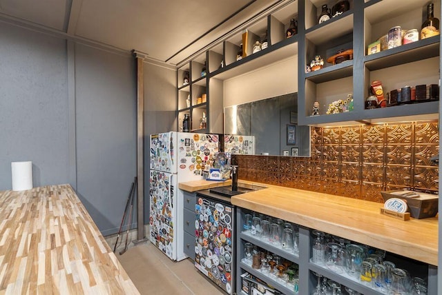 497 E Kossuth St, Columbus, OH 43206 - indoor wet bar featuring decorative backsplash, freestanding refrigerator, and light tile patterned flooring