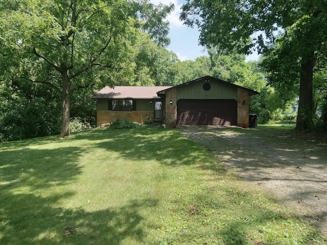 6978 Cook-Jones Rd, Waynesville, OH 45068 - view of front of home with dirt driveway, an attached garage, stone siding, and a front lawn