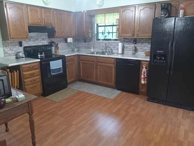 6978 Cook-Jones Rd, Waynesville, OH 45068 - kitchen featuring black appliances, under cabinet range hood, light countertops, backsplash, and light wood-style flooring