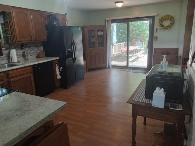 6978 Cook-Jones Rd, Waynesville, OH 45068 - kitchen featuring black appliances, wood finished floors, light countertops, tasteful backsplash, and brown cabinets