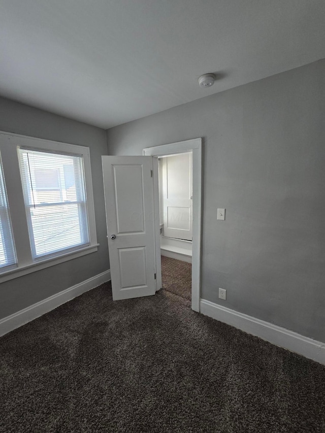 2205-2207 Sullivant Ave, Columbus, OH 43223 - unfurnished bedroom featuring dark colored carpet and baseboards
