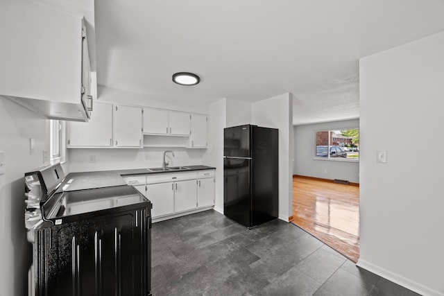1033 Folkestone Rd, Columbus, OH 43220 - kitchen featuring freestanding refrigerator, white cabinets, electric range oven, and dark countertops