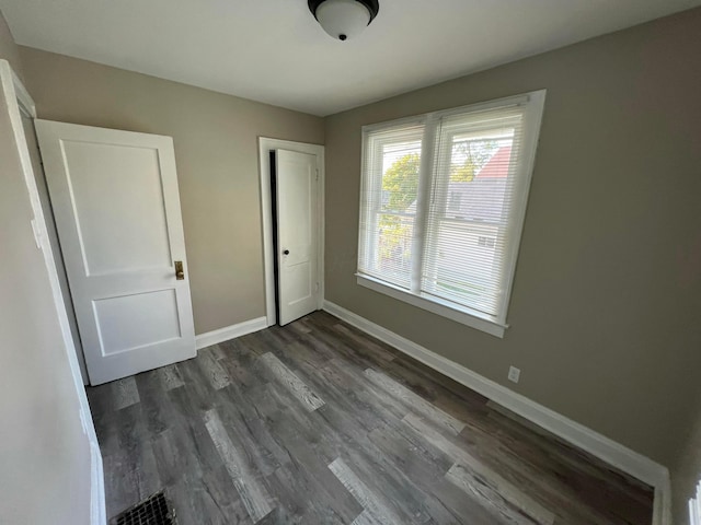 1514-1516 E 26th Ave, Columbus, OH 43211 - unfurnished bedroom with dark wood-style flooring and a closet