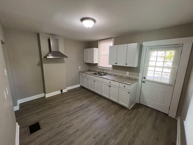 1514-1516 E 26th Ave, Columbus, OH 43211 - kitchen featuring wall chimney range hood, white cabinetry, dark wood-style flooring, and light countertops