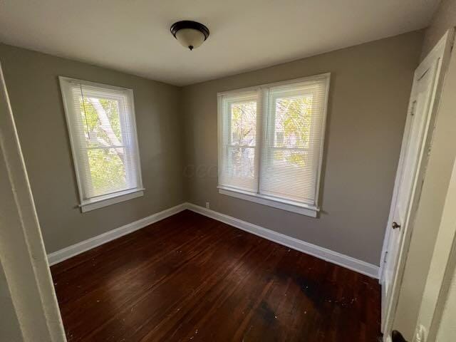 1514-1516 E 26th Ave, Columbus, OH 43211 - unfurnished bedroom with dark wood-style flooring and multiple windows