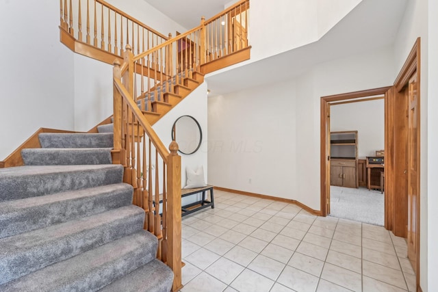 1318 Retreat Ln, New Albany, OH 43054 - stairway featuring a high ceiling and tile patterned floors