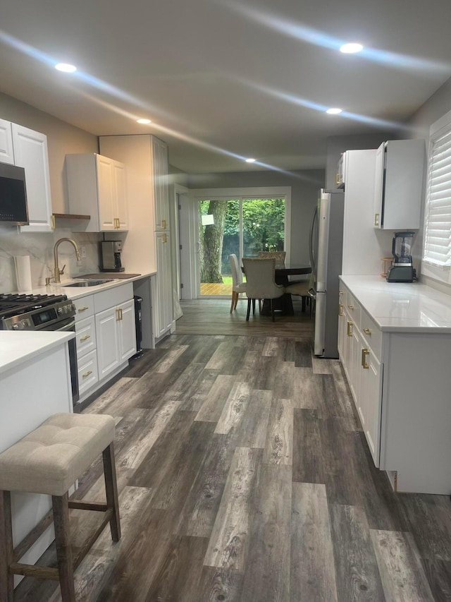 3107 Huntington Dr, Columbus, OH 43207 - kitchen with appliances with stainless steel finishes, white cabinets, dark wood-type flooring, light countertops, and recessed lighting