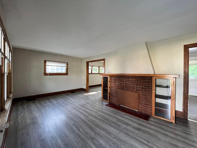 1015 Fairwood Ave, Columbus, OH 43206 - unfurnished living room featuring dark wood-style flooring, plenty of natural light, and a fireplace
