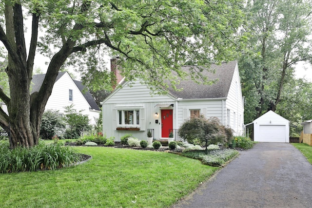 595 Brookside Dr, Columbus, OH 43209 - view of front facade featuring roof with shingles, a chimney, an outdoor structure, a front yard, and asphalt driveway