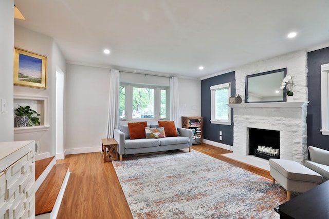 595 Brookside Dr, Columbus, OH 43209 - living room with light wood-style flooring, a stone fireplace, recessed lighting, and crown molding