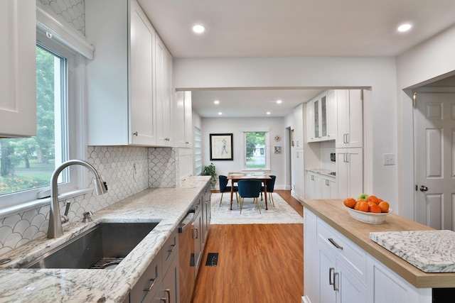 595 Brookside Dr, Columbus, OH 43209 - kitchen featuring light wood-style flooring, healthy amount of natural light, white cabinetry, recessed lighting, and light stone countertops