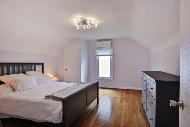 595 Brookside Dr, Columbus, OH 43209 - bedroom featuring vaulted ceiling, a wall mounted air conditioner, and wood-type flooring