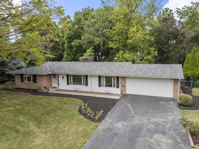 4289 Shelbourne Ln, Columbus, OH 43220 - single story home with brick siding, asphalt driveway, a front lawn, a garage, and a chimney