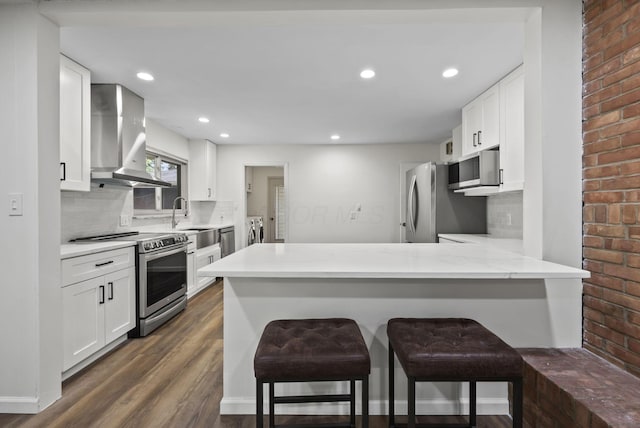4289 Shelbourne Ln, Columbus, OH 43220 - kitchen featuring appliances with stainless steel finishes, washing machine and dryer, island exhaust hood, dark wood-style flooring, and decorative backsplash