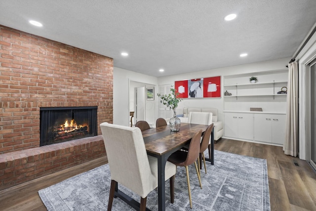 4289 Shelbourne Ln, Columbus, OH 43220 - dining area featuring a textured ceiling, dark wood-type flooring, a fireplace, and recessed lighting