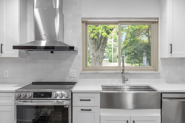 4289 Shelbourne Ln, Columbus, OH 43220 - kitchen with wall chimney range hood, appliances with stainless steel finishes, white cabinetry, backsplash, and light countertops