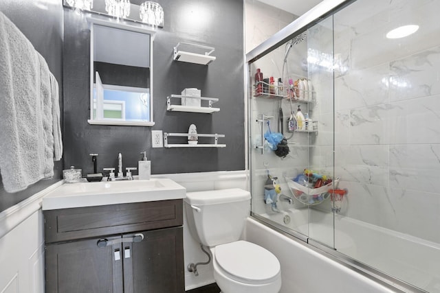 372 Sturbridge Rd, Columbus, OH 43228 - bathroom featuring combined bath / shower with glass door, vanity, and a wainscoted wall