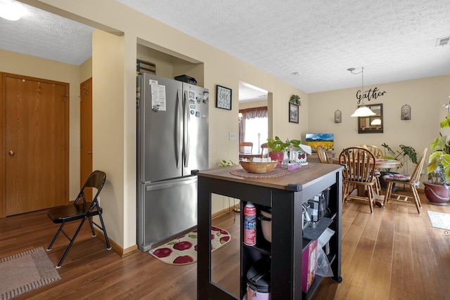 50 Bazler Ln, South Bloomfield, OH 43103 - kitchen featuring freestanding refrigerator, a textured ceiling, wood-type flooring, and hanging light fixtures