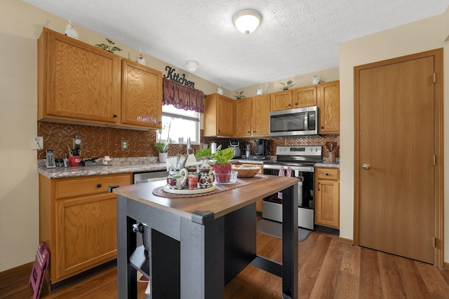 50 Bazler Ln, South Bloomfield, OH 43103 - kitchen with appliances with stainless steel finishes, a textured ceiling, decorative backsplash, wood finished floors, and butcher block counters