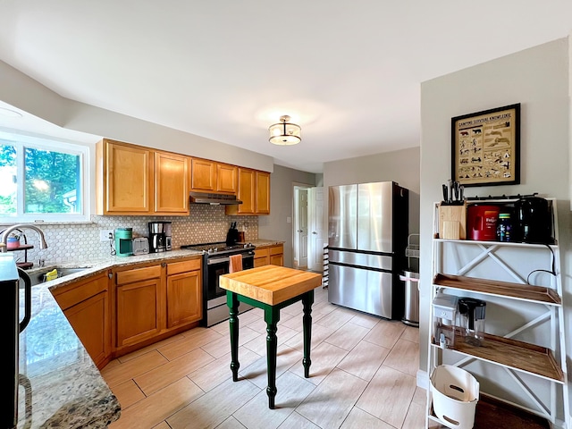 4713 Haughn Rd, Grove City, OH 43123 - kitchen featuring stainless steel appliances, under cabinet range hood, backsplash, brown cabinetry, and wood tiled floors