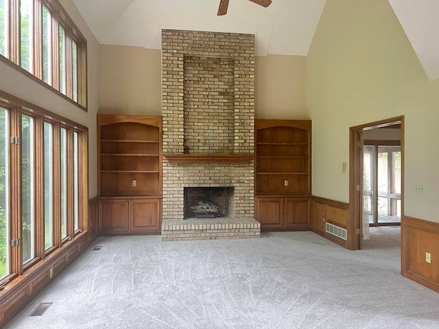 471 Old Mill Dr, Columbus, OH 43230 - unfurnished living room featuring high vaulted ceiling, a ceiling fan, a wainscoted wall, a brick fireplace, and light carpet