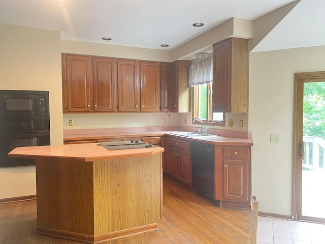 471 Old Mill Dr, Columbus, OH 43230 - kitchen featuring black appliances, light countertops, a center island, and light wood-type flooring