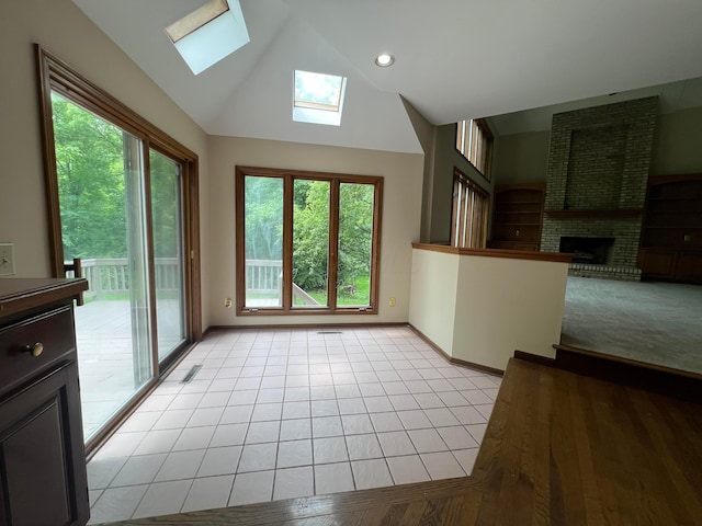 471 Old Mill Dr, Columbus, OH 43230 - unfurnished living room featuring a skylight, vaulted ceiling, and a brick fireplace