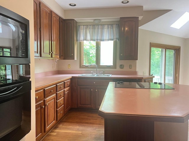 471 Old Mill Dr, Columbus, OH 43230 - kitchen with black appliances, a center island, light countertops, and light wood finished floors