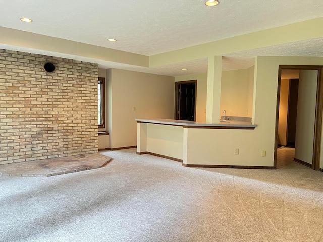 471 Old Mill Dr, Columbus, OH 43230 - unfurnished living room featuring light carpet, wet bar, recessed lighting, brick wall, and a textured ceiling