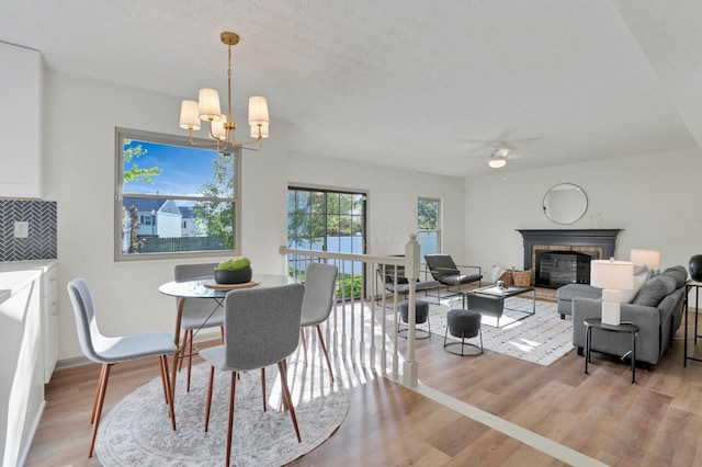 8139 Storrow Dr, Westerville, OH 43081 - dining room with a ceiling fan, a glass covered fireplace, light wood finished floors, and a chandelier