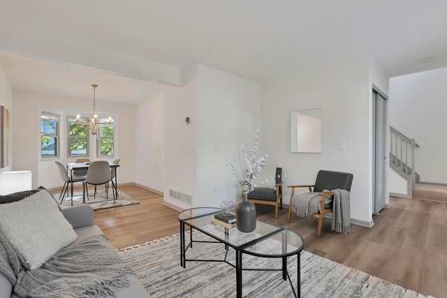 8139 Storrow Dr, Westerville, OH 43081 - living room featuring light wood-style floors, a chandelier, and stairway