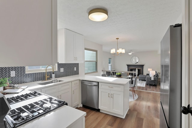 8139 Storrow Dr, Westerville, OH 43081 - kitchen with appliances with stainless steel finishes, open floor plan, tasteful backsplash, white cabinets, and a peninsula